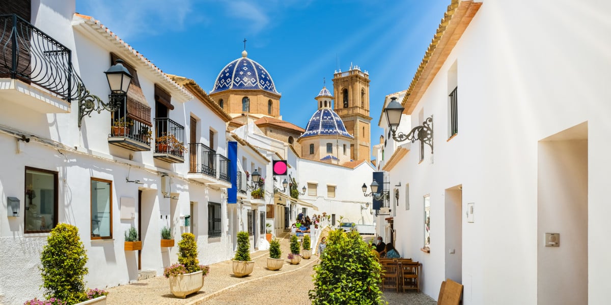 Altea street view featuring bright blue sky and the iconic blue ceiling of the church in Costa Blanca, Spain.