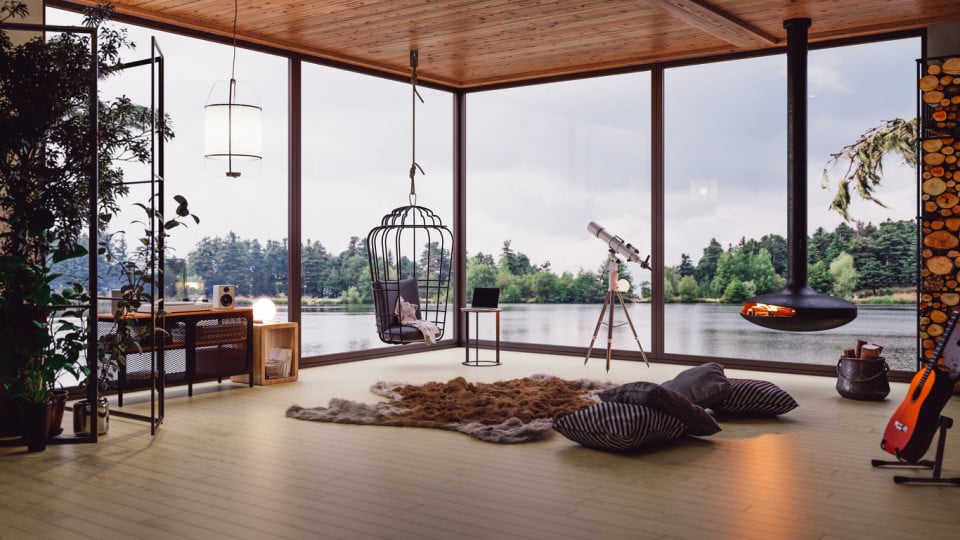 Contemporary living room with floor-to-ceiling windows overlooking a tranquil lake, featuring minimalist furniture, a hanging chair, and a cozy fireplace