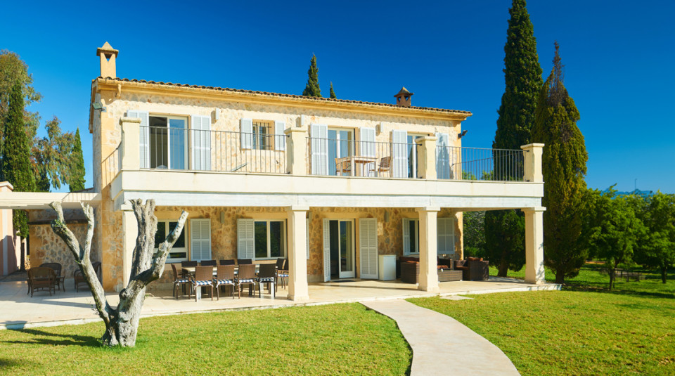 Beautiful yellow rural house located in the sunshine with the countryside on the horizon