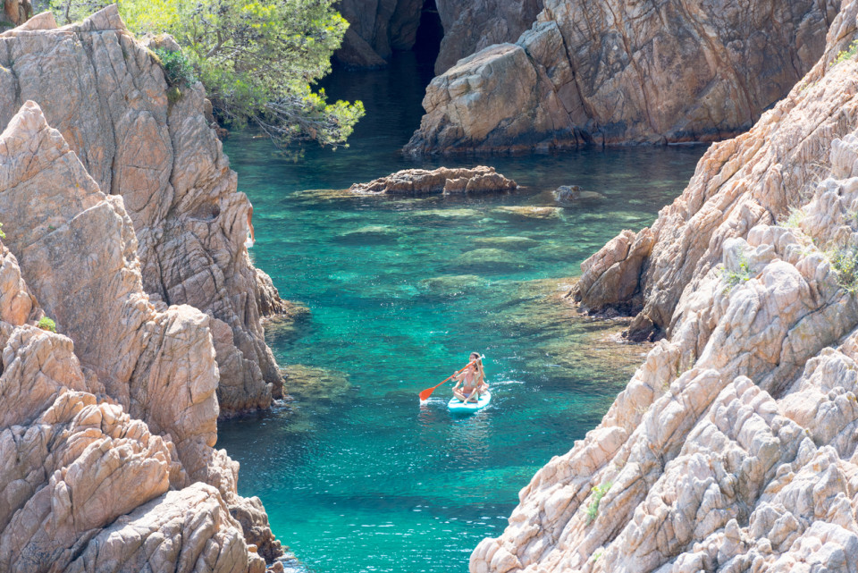 Sea, rocks, paddle board, people
