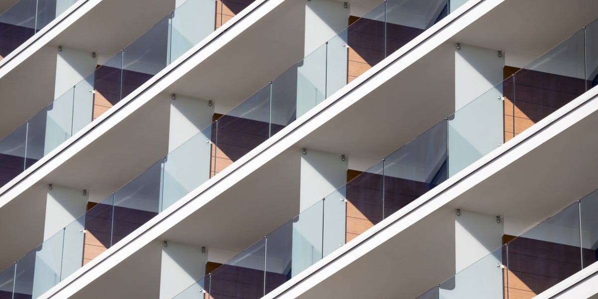 Modern luxury building with transparent glass balconies and panoramic views, upscale residential property with contemporary architectural design