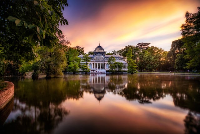Beautiful sunset, overlooking the horizon of the retiro park in madrid where nature borders the crystal palace in a wonderful sunset.
