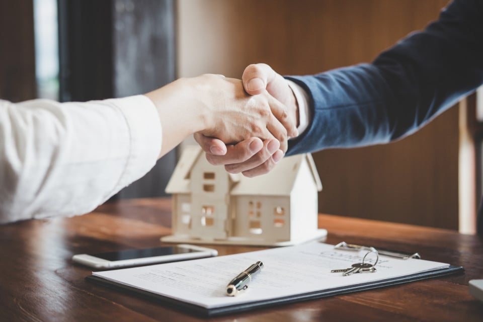 Two people shaking hands representing successful home sale agreements