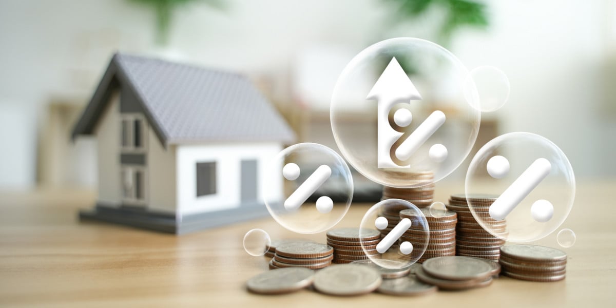 Illustration of a house next to stacks of money with a elements showing tax information, symbolizing property taxes.
