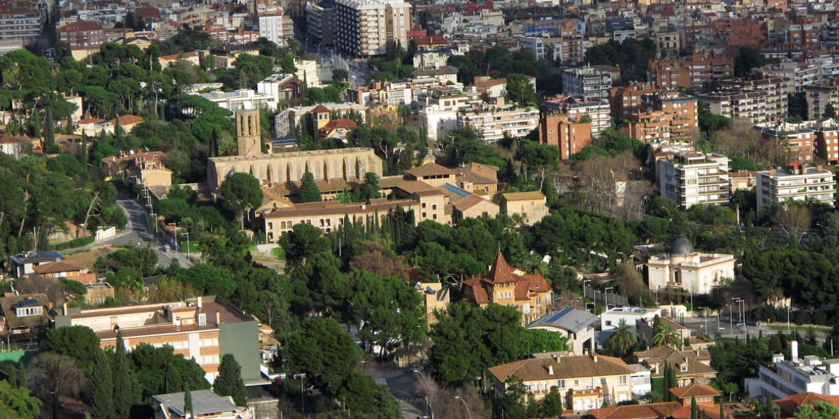Aerial view of the Zona Alta of Barcelona showing elegant residential buildings surrounded by greenery and historic landmarks.