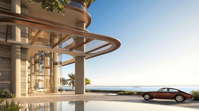 Beautiful photo of the new brand new housing complex showing an antique car parked in the lobby of the tower overlooking the sea.